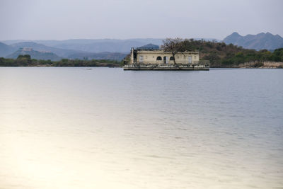 Scenic view of lake pichola against grey sky