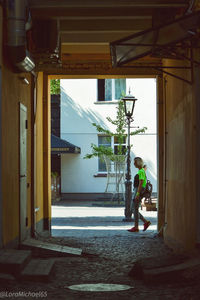 Rear view of man working at entrance of building