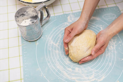 Woman kneading dough with hands, baker's hands, silicone mat, sieve