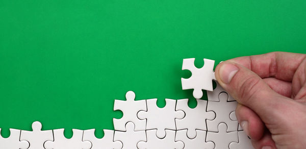 Close-up of hand arranging jigsaw puzzle