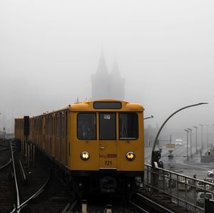 Train on railroad tracks in foggy weather against sky