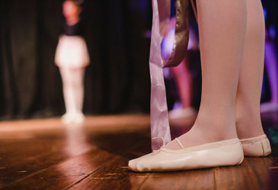 Low section of woman standing on hardwood floor