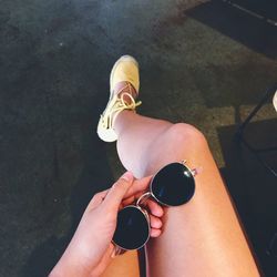High angle view of woman holding sunglasses while sitting at home