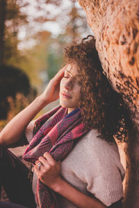 Close-up of woman with tree trunk