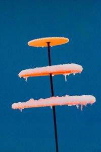 Low angle view of orange slice against blue sky
