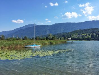 Boats in river with mountain range in background