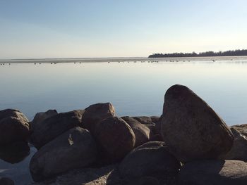 Rocks on sea shore against sky