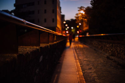 Surface level of footpath amidst buildings at night