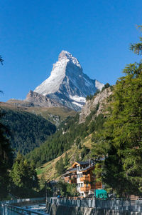 Scenic view of lake by mountains against clear sky