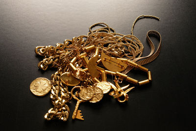 High angle view of golden jewelries on black background