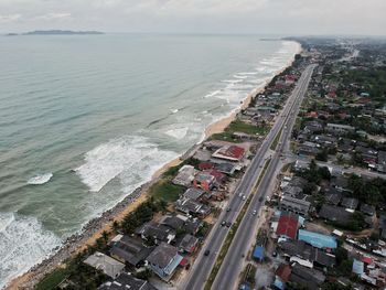 High angle view of city by sea against sky