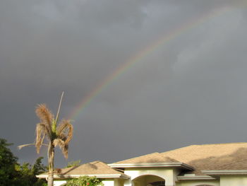 Rainbow over building against sky