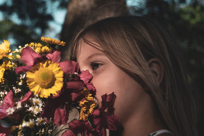 Close-up of young woman with red flower
