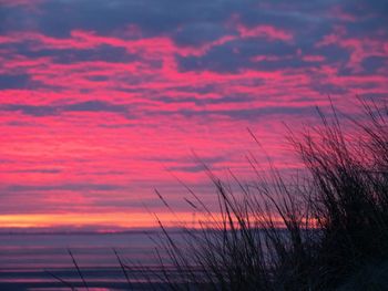 Scenic view of sea against dramatic sky during sunset
