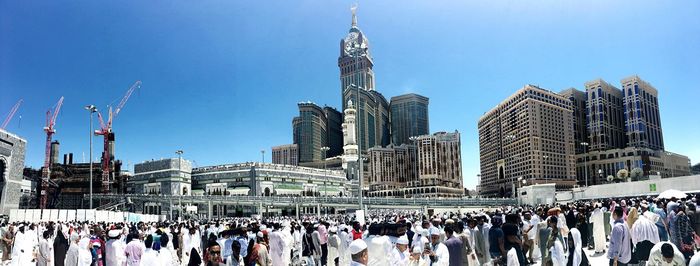 Panoramic view of crowd in city against clear blue sky