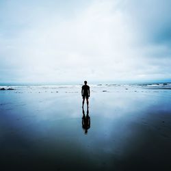 Rear view of man standing on beach