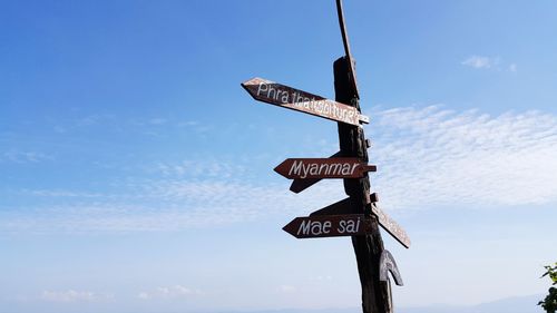 Low angle view of road sign against blue sky