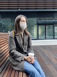 Full length of young woman drinking coffee