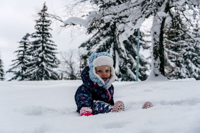 Portrait of smiling girl skiing on snow covered field