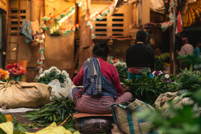 Rear view of man for sale at market stall