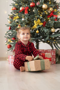 Portrait of cute girl playing with christmas tree