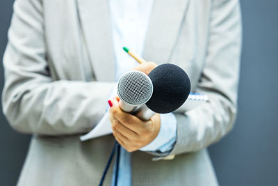 Female reporter at news conference, writing notes, holding microphone. freedom of the press concept.