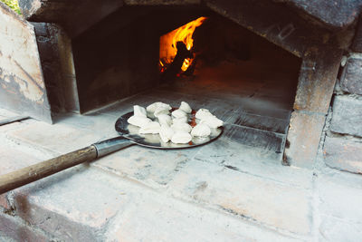 Small dough balls on paddle ready to bake. homemade small breads are getting into stone oven.