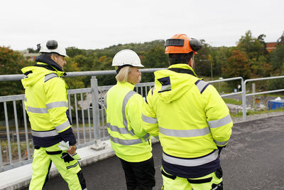 Engineers in reflective clothing walking on bridge