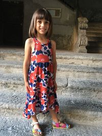 Portrait of smiling cute girl standing on staircase