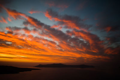 Scenic view of sea against dramatic sky during sunset