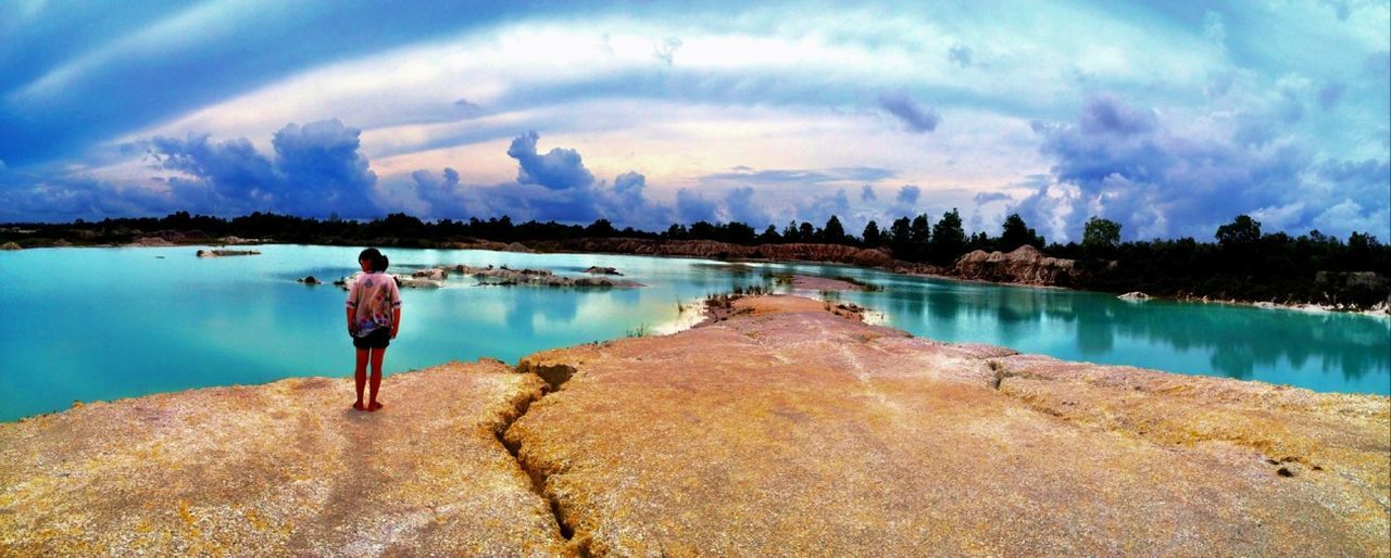 water, sky, cloud - sky, standing, lifestyles, tranquil scene, tranquility, scenics, rear view, leisure activity, beauty in nature, lake, full length, cloud, blue, nature, reflection, men