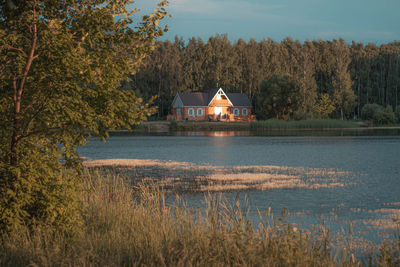 Scenic view of lake by building against sky