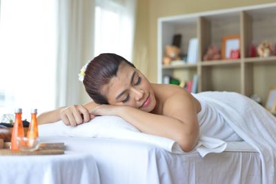 Portrait of woman lying on bed at home