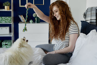 Young woman with cat sitting at home