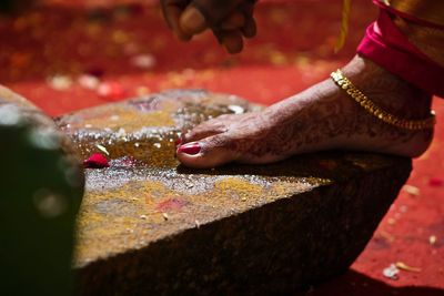 Low section of bride wearing gold anklet during wedding