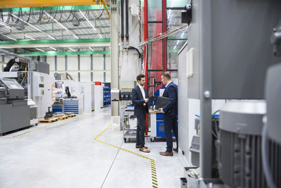 Two businessmen in factory shop floor