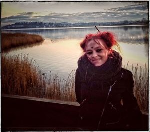 Portrait of smiling woman in lake during winter