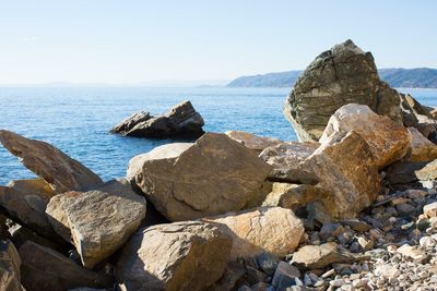 Rocks on beach against clear sky