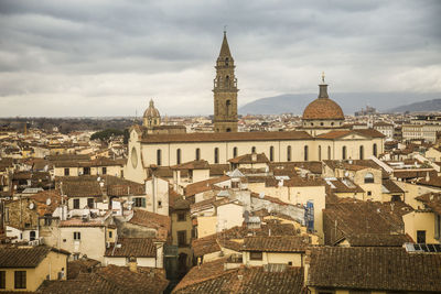 Buildings in city against cloudy sky