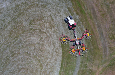 Drone view of tractor with rotary rakes turning hay