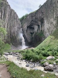 Scenic view of waterfall against sky