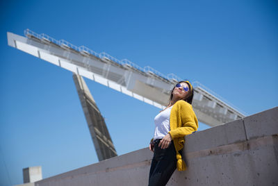 Low angle view of man standing against blue sky