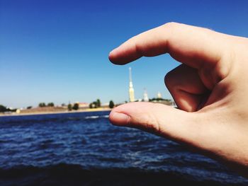 Close-up of cropped hand holding blue water