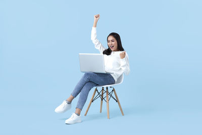 Man sitting on chair against white background