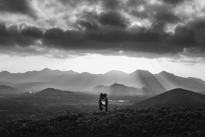 Dog running on mountain against sky