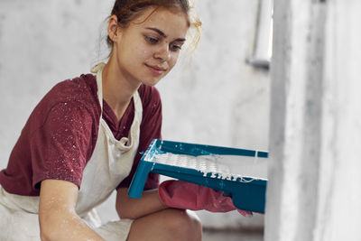 Side view of young woman using mobile phone