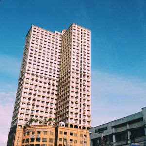 Low angle view of modern building against blue sky