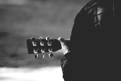 Cropped image of man playing guitar on street