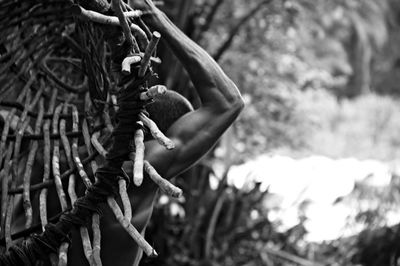 Woman holding hands while standing on tree trunk