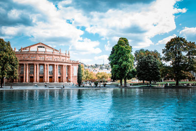 Swimming pool in building against cloudy sky